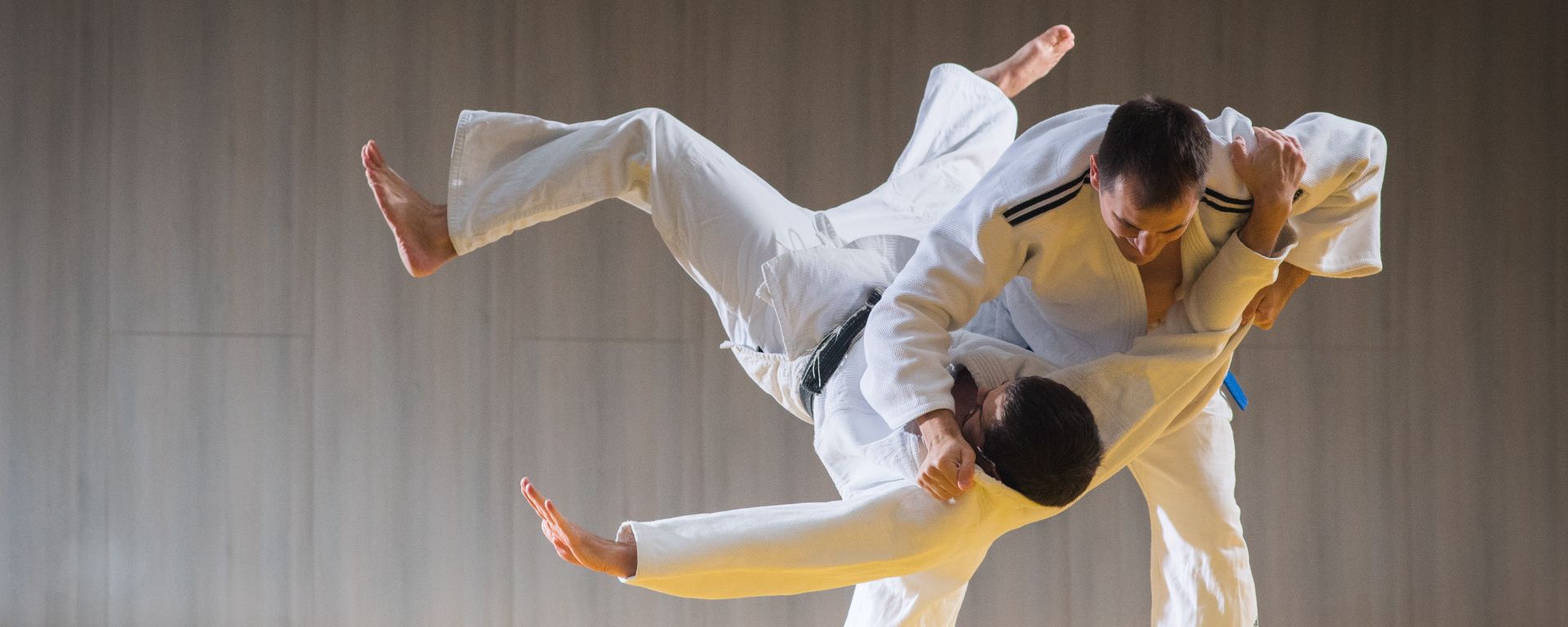 Zwei Personen beim Judo, eine wird geworfen.